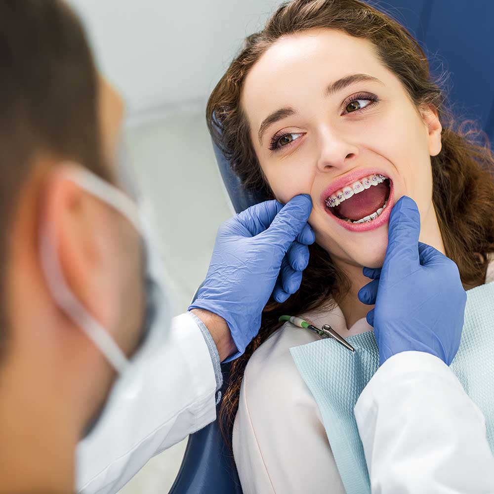 Portrait of Woman Having Her Braces Maintained by a Dentist at Ennis Family Dental