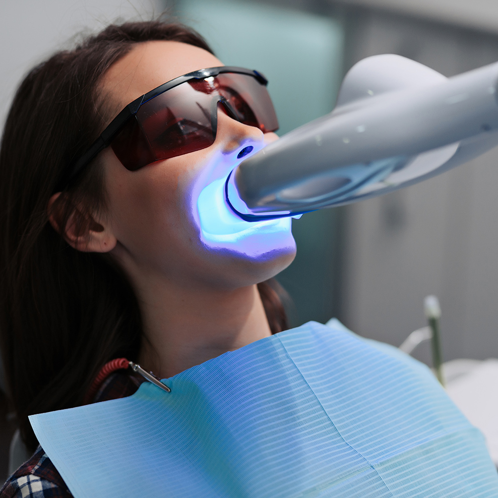 Portrait of Woman Wearing UV Protection Glasses as She Gets Her Teeth Whitened at Ennis Family Dental